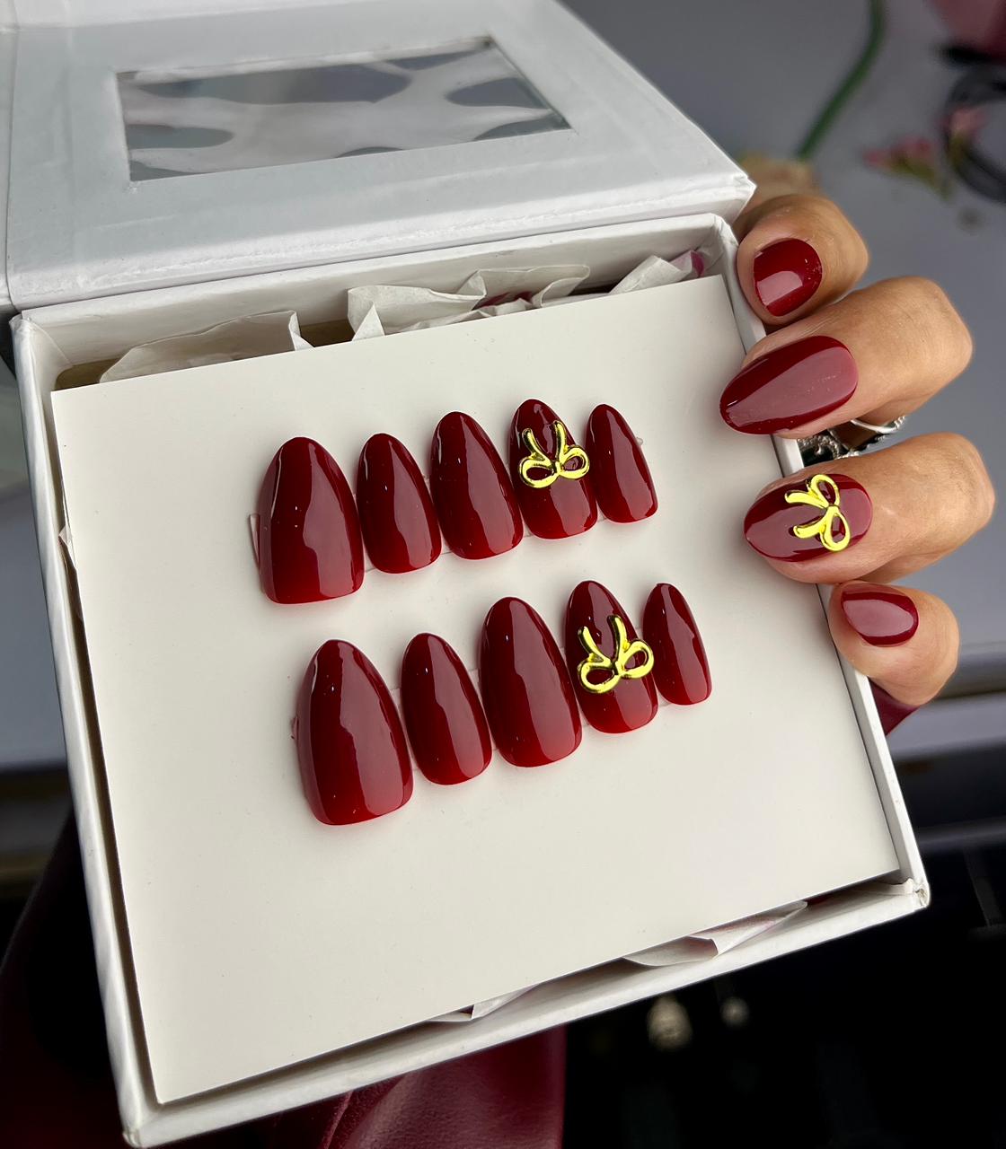 Cherry red nails with golden bow
