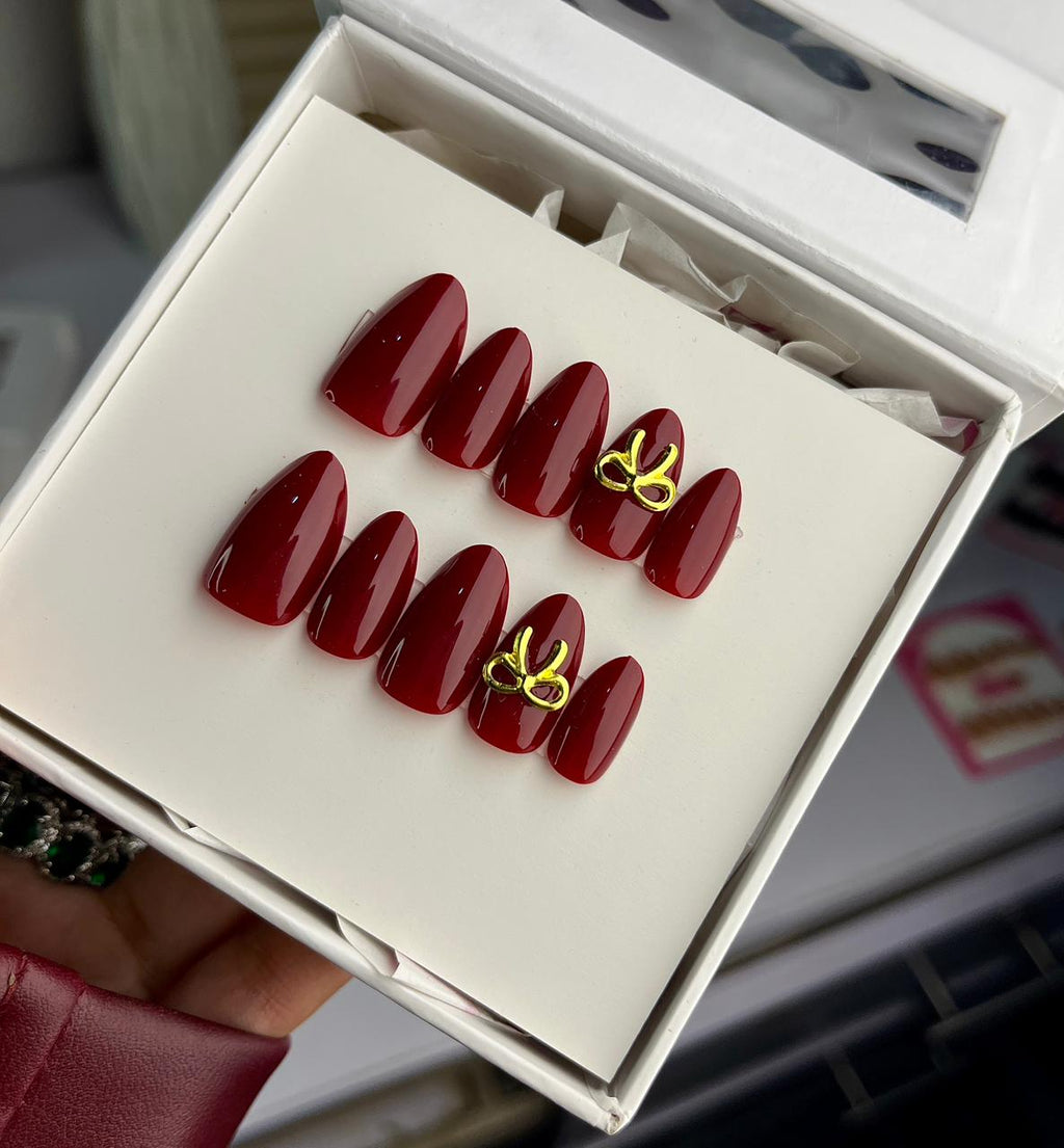 Cherry red nails with golden bow